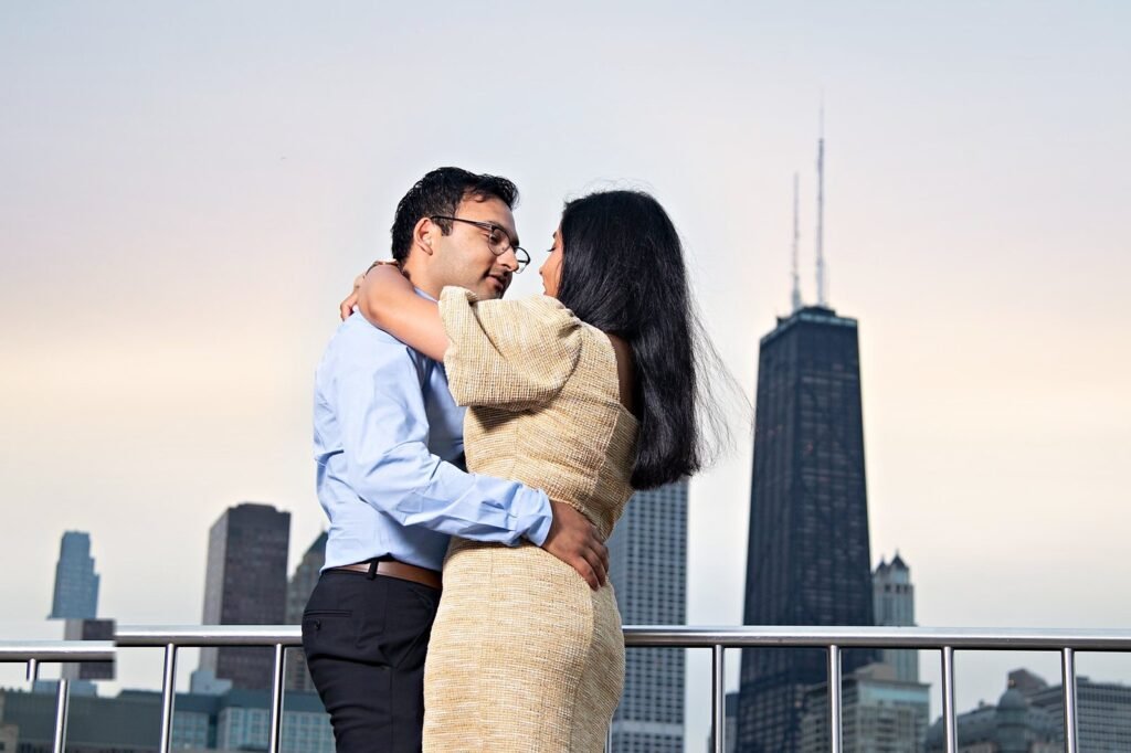 Couple embracing with the John Hancock Center and Chicago skyline glowing at golden-hour sunset