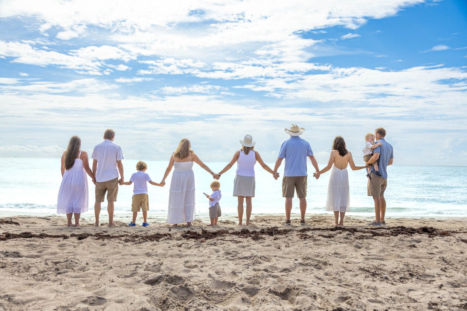 Family walking hand in hand along the beach during a West Palm Beach family photo session