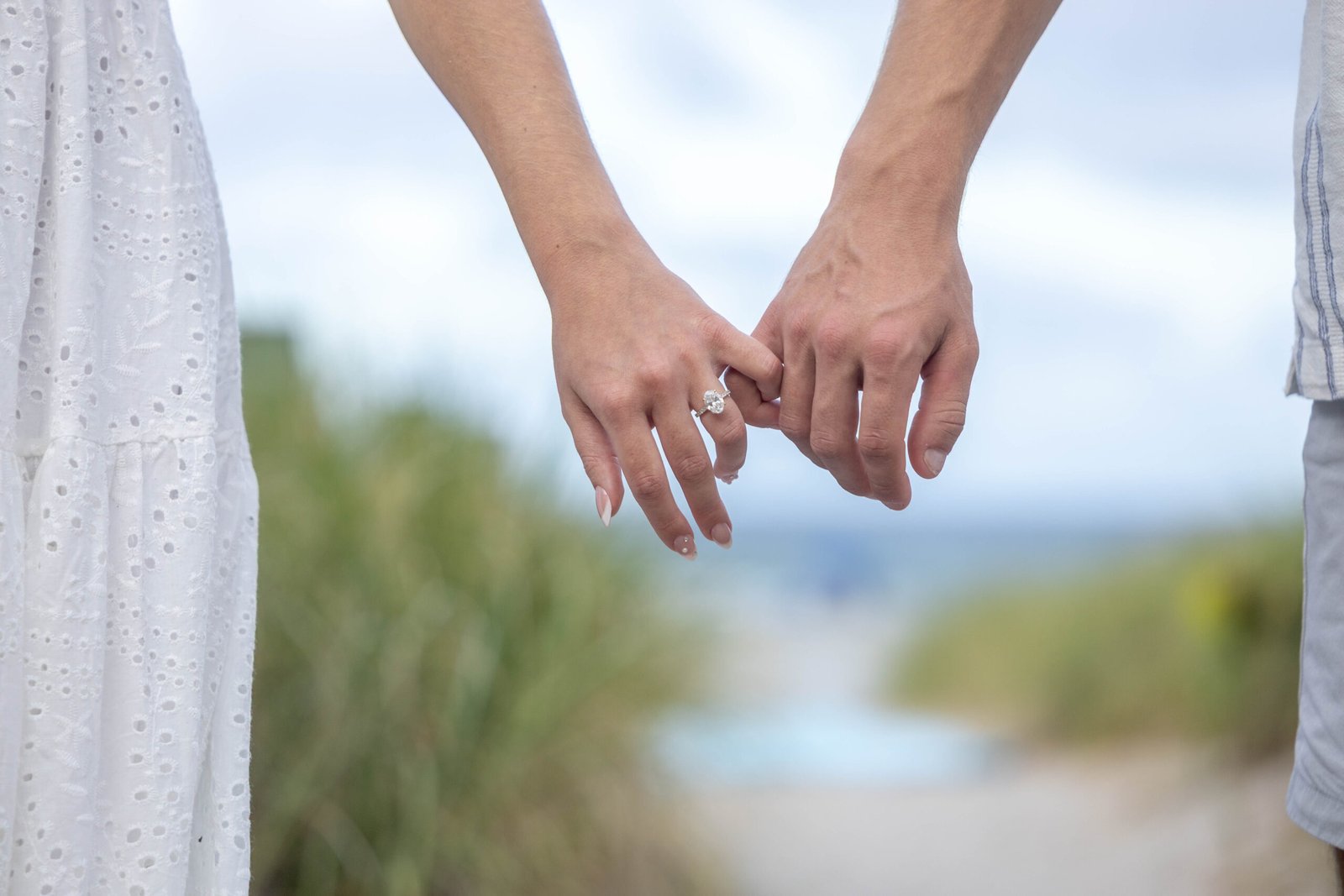 Engaged couple holding hands showing rings West Palm Beach