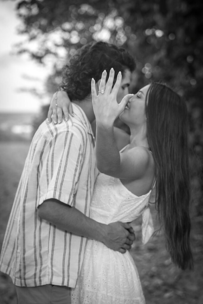 Black and white engagement kiss showing ring West Palm Beach engagement photographer artistic