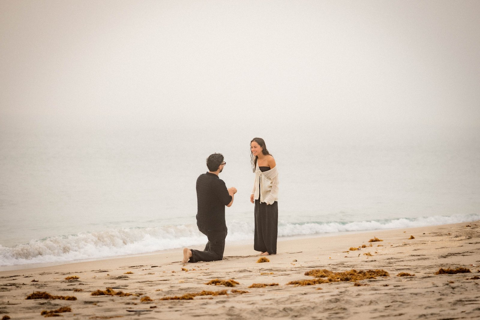 Beach proposal with ocean waves man proposing West Palm Beach engagement photographer sunset