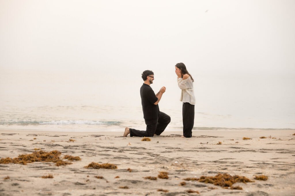 Beach proposal man kneeling proposing to woman West Palm Beach engagement photographer romantic moment