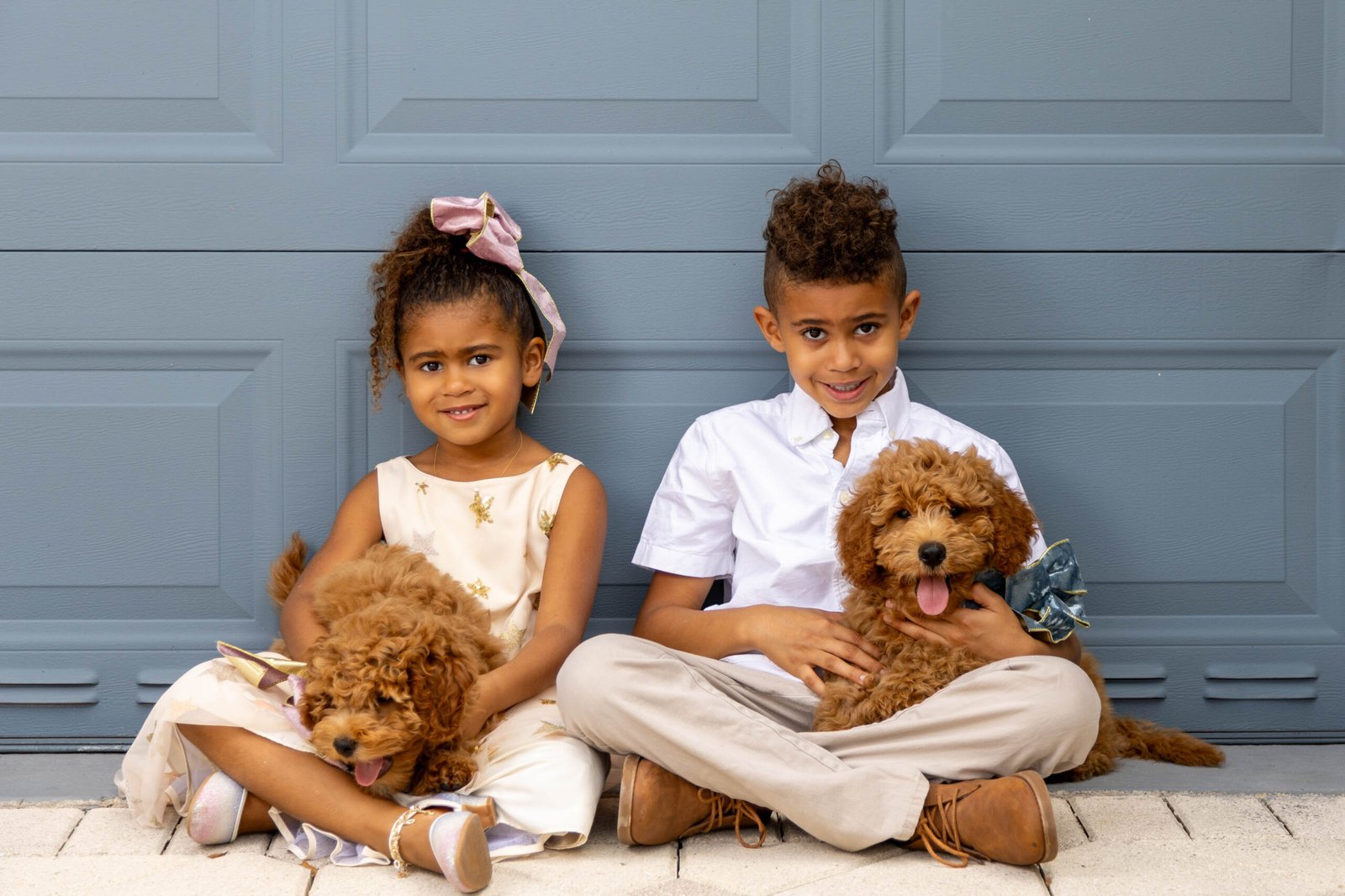 Two children sitting with their puppies during a children's photo session in West Palm Beach