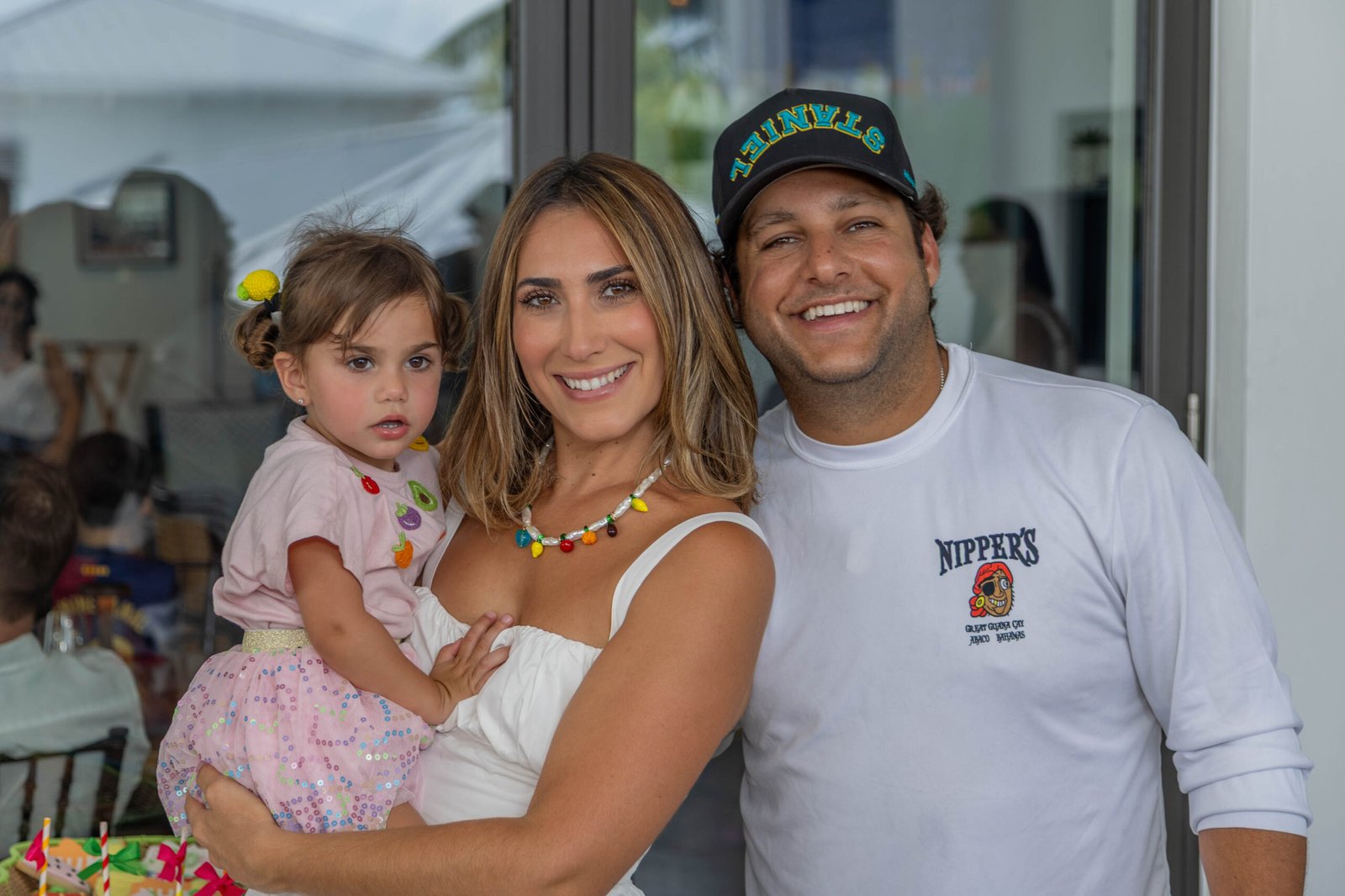 Parents holding their baby girl at a celebration in West Palm Beach