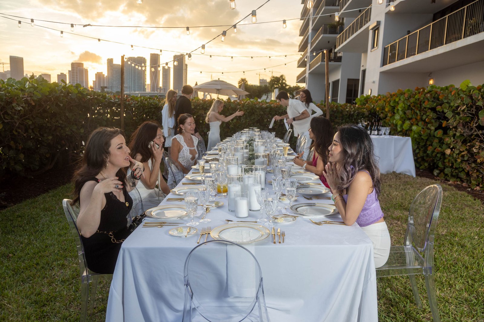 Guests at an elegant outdoor dinner event at sunset in Miami