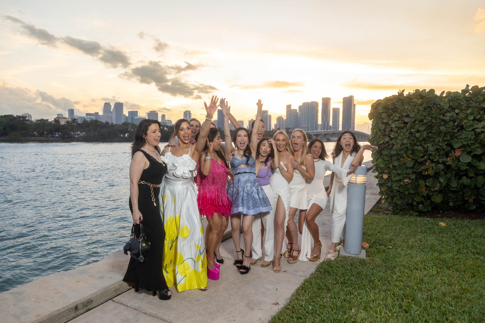 Guests celebrating with raised arms at sunset during an outdoor event in Miami