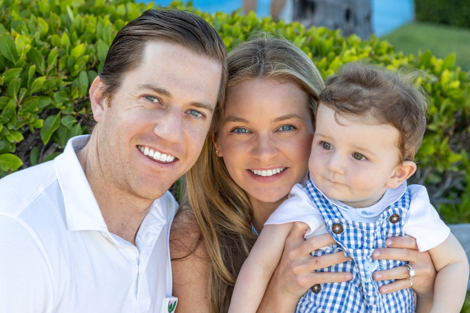 Close-up family portrait with father, mother, and young son smiling in outdoor session