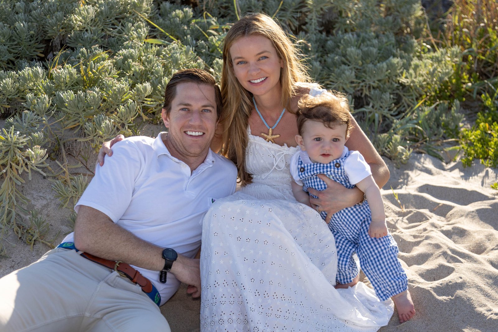 Family in soft neutral outfits sitting in the beach dunes in West Palm Beach