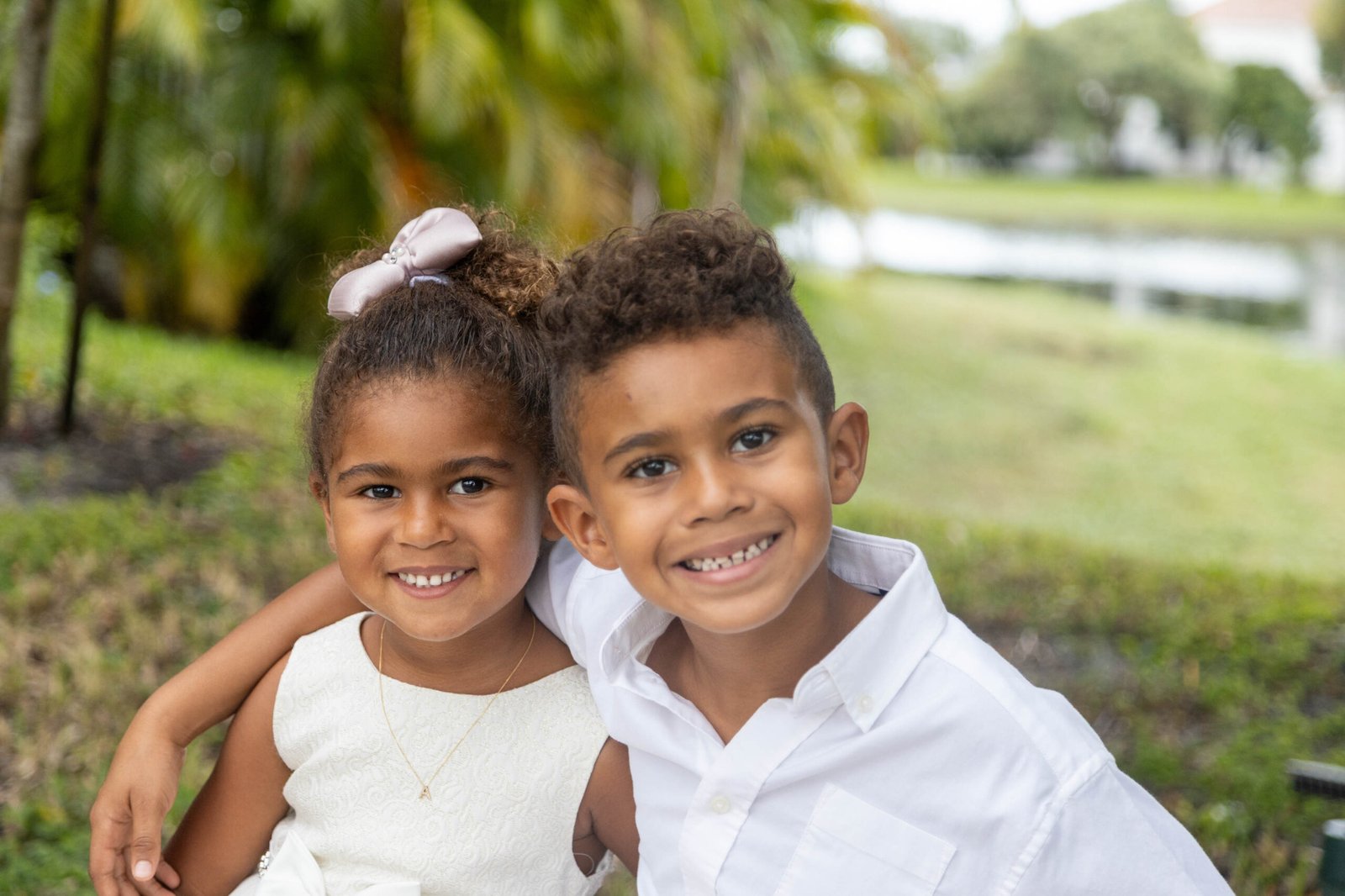 Two children smiling together outdoors during a West Palm Beach kids photo session