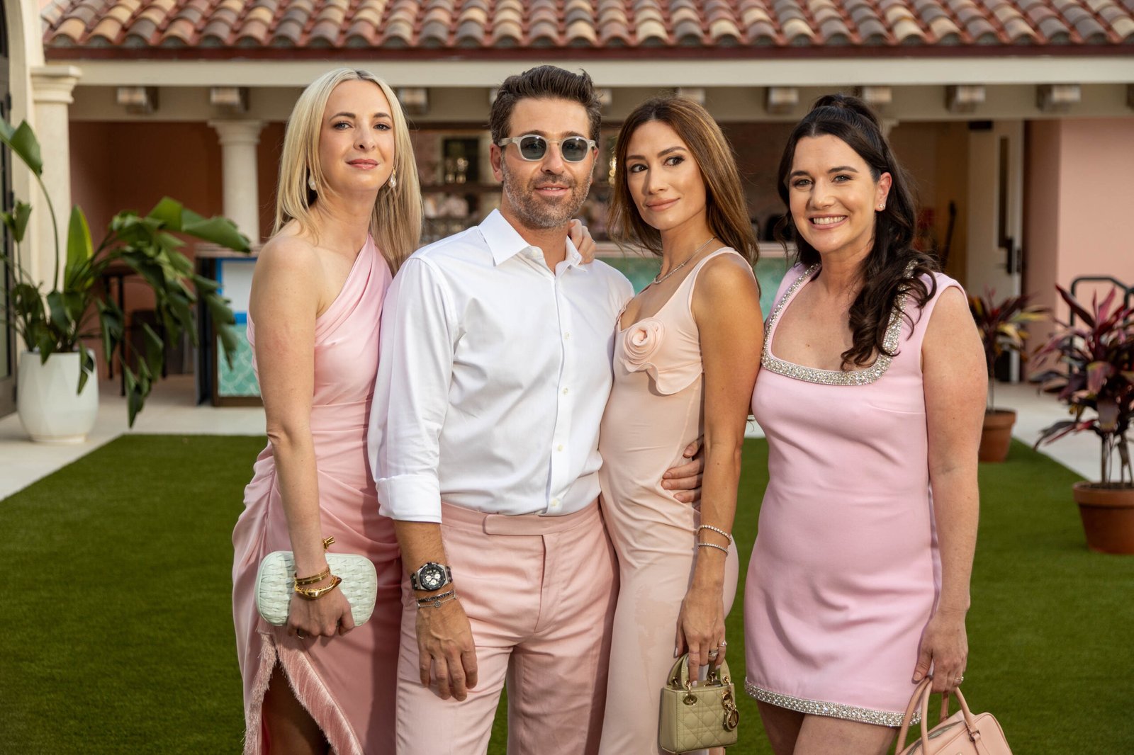 Well-dressed guests networking in a garden at a Palm Beach event