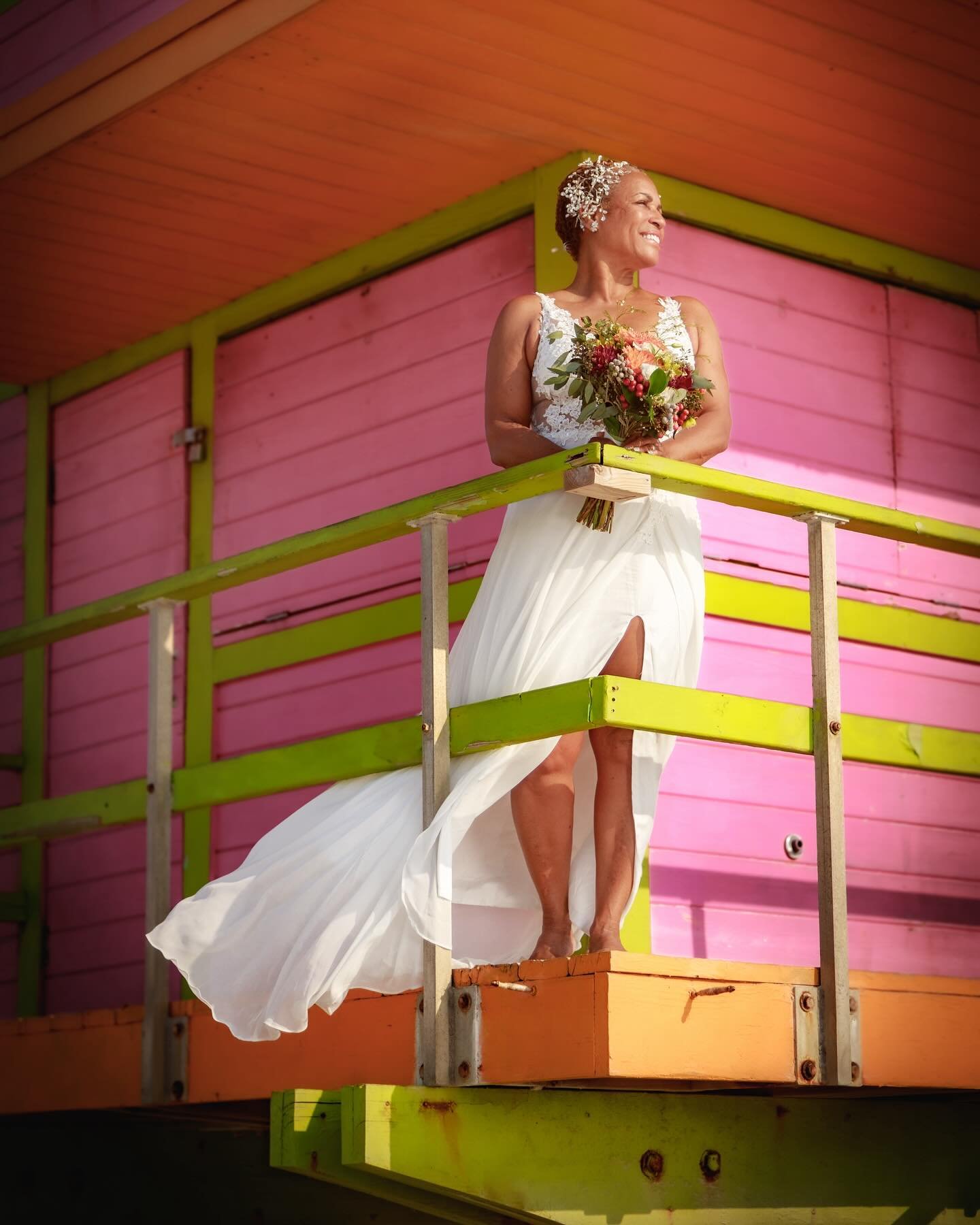 Bride in a flowing white gown holding her bouquet at a South Florida beach wedding, photographed by The Love Pics