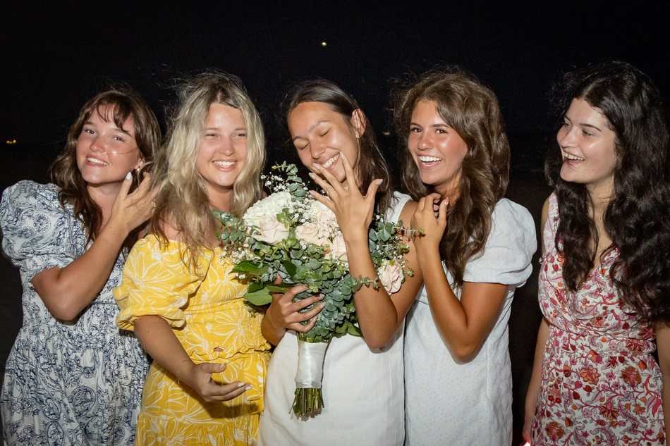 Bride-to-be celebrating her engagement with friends admiring the ring on a West Palm Beach beach