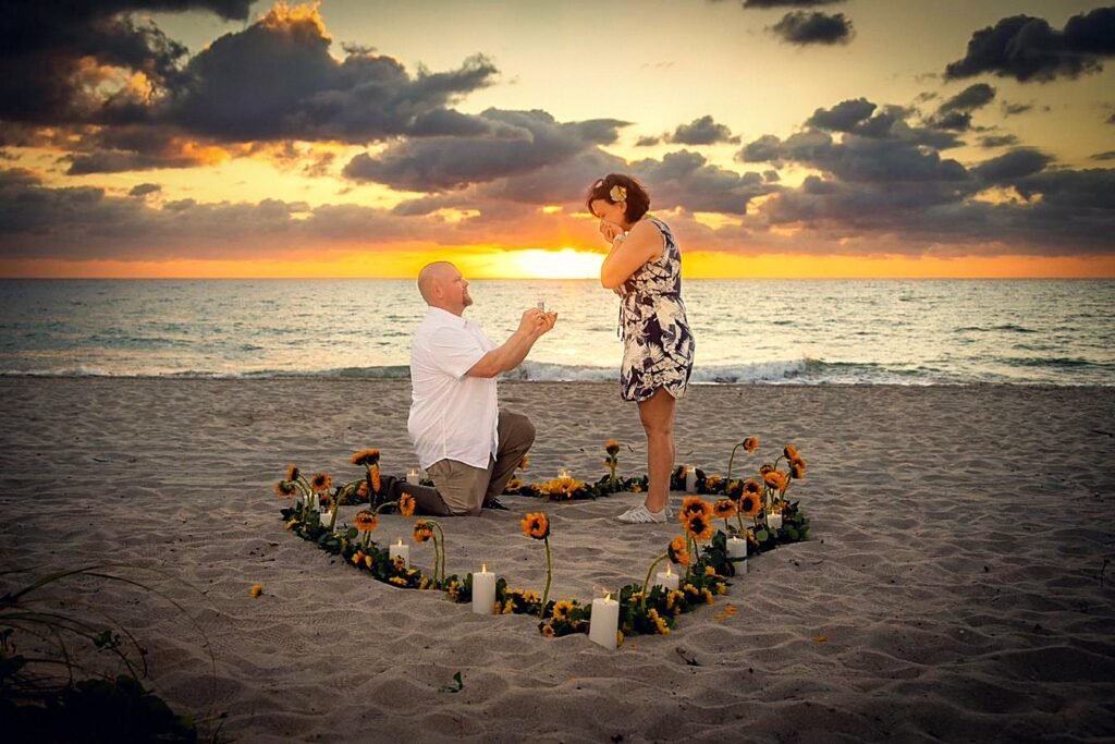 Surprise sunrise marriage proposal inside a heart of sunflowers and candles as the sun rises over the ocean at Las Olas Beach, Fort Lauderdale, photographed by The Love Pics.