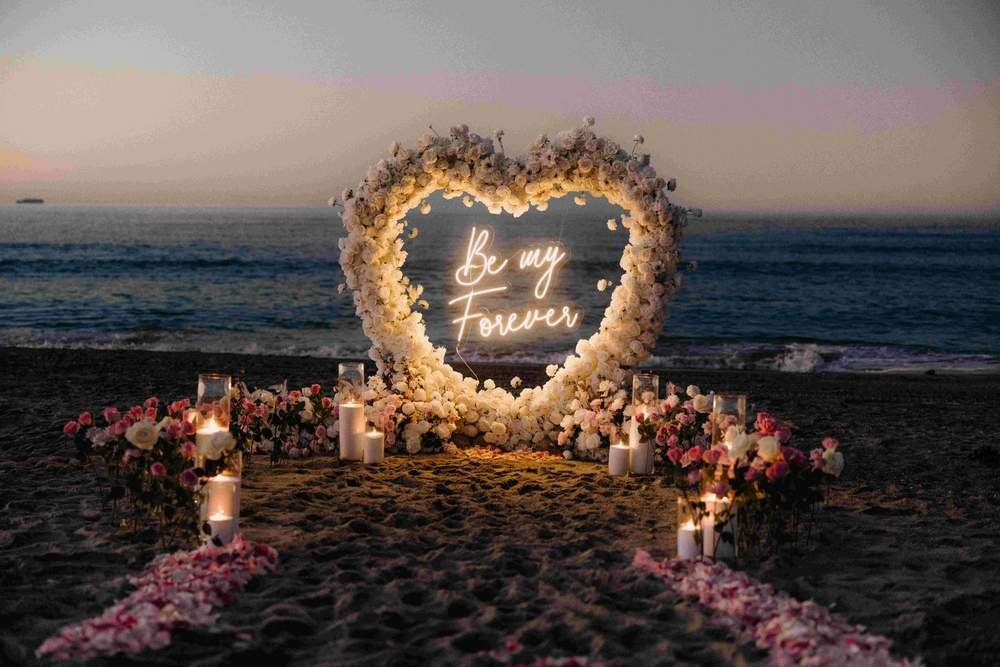 Heart-shaped floral arch proposal set-up on the beach in West Palm Beach by The Love Pics