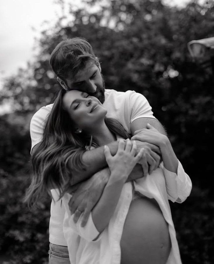 Black and white maternity portrait of a couple holding the bump