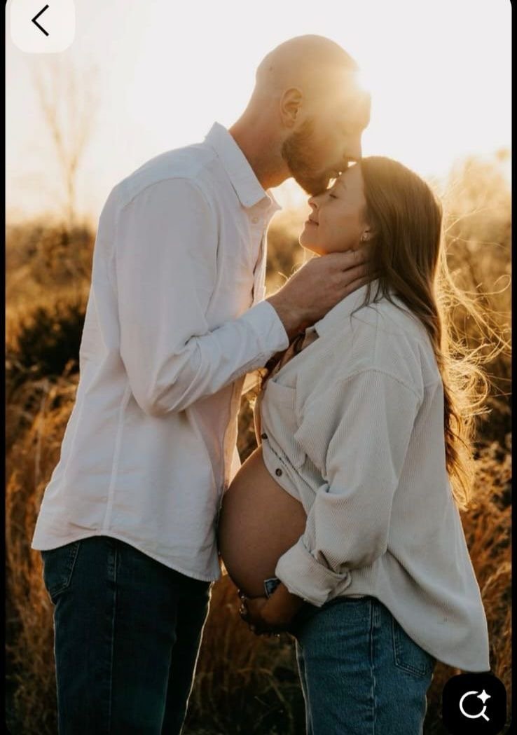 Expecting couple embracing in warm evening light