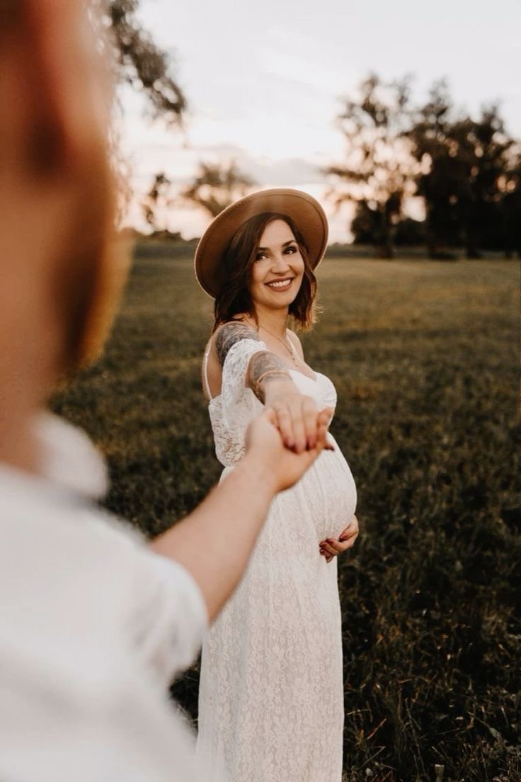 Maternity portrait of a mother-to-be in a field at sunset