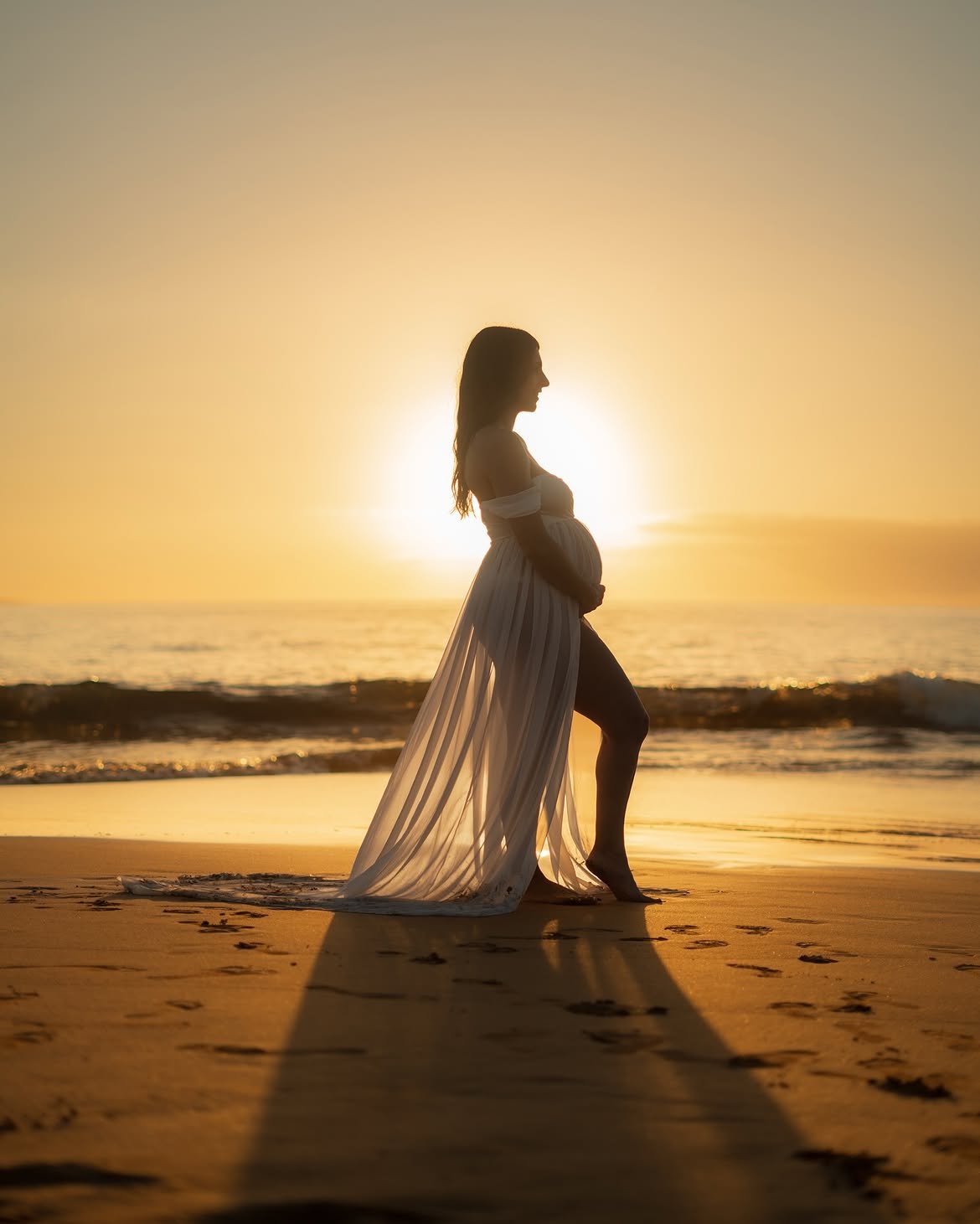Maternity portrait silhouetted against the ocean sunset in West Palm Beach