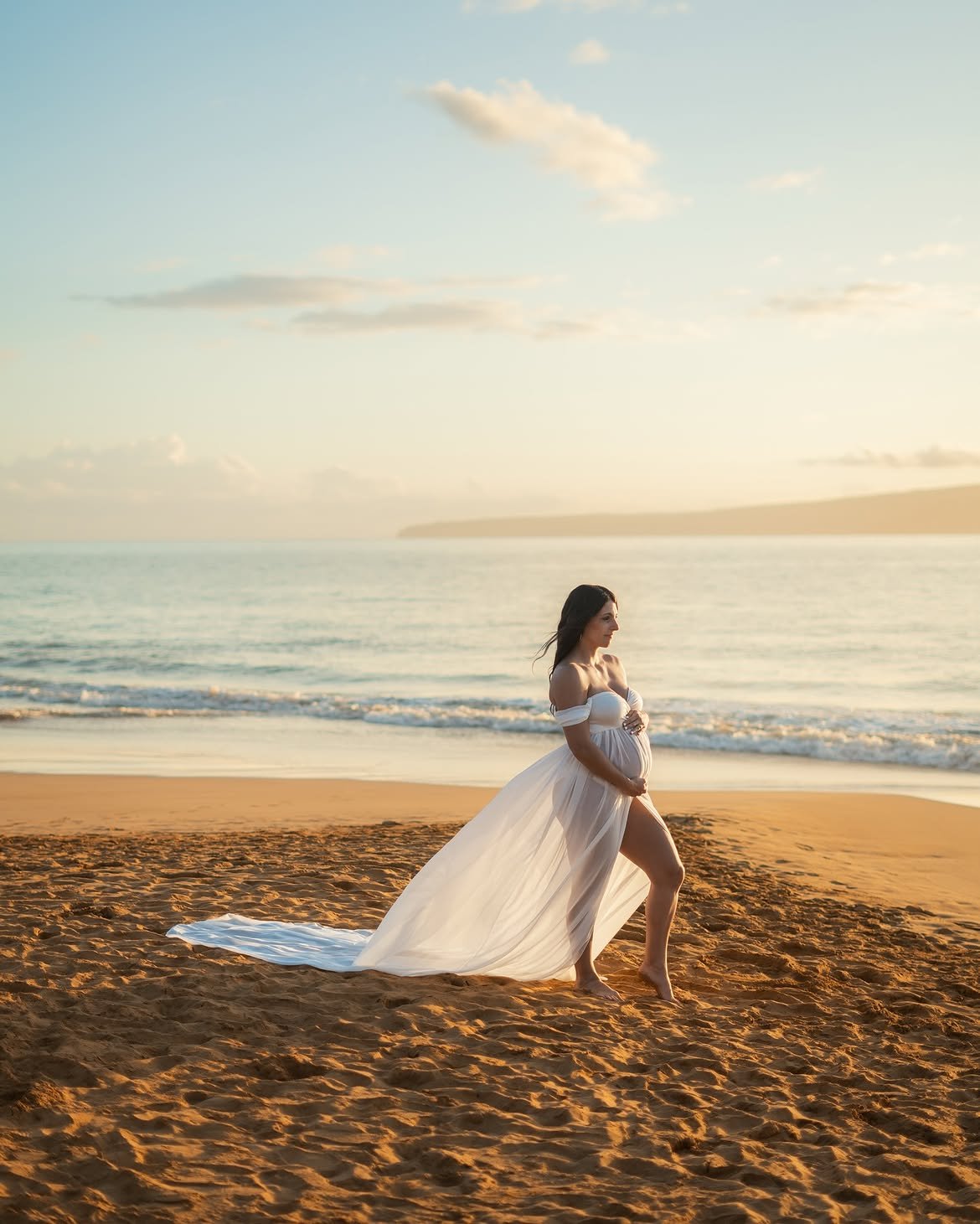 Mother-to-be walking along the shoreline during a maternity session