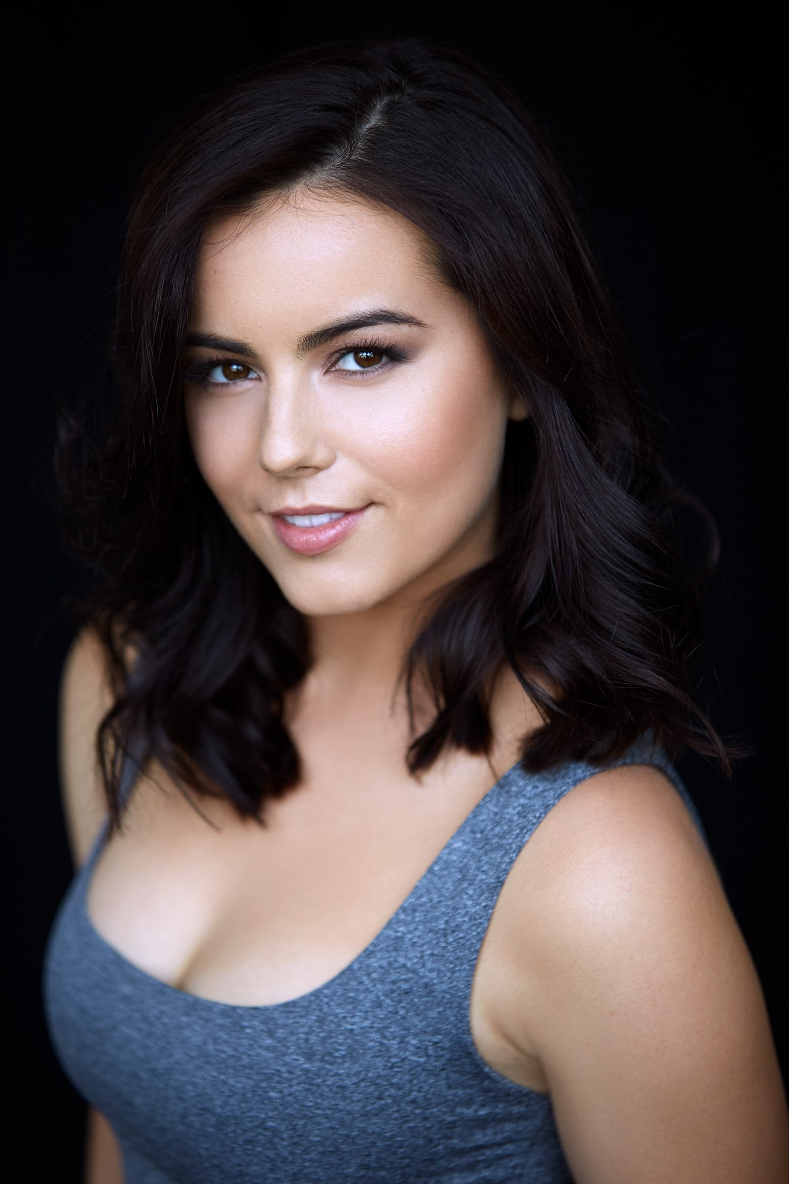 Professional headshot showing a solid dark top that keeps attention on the face