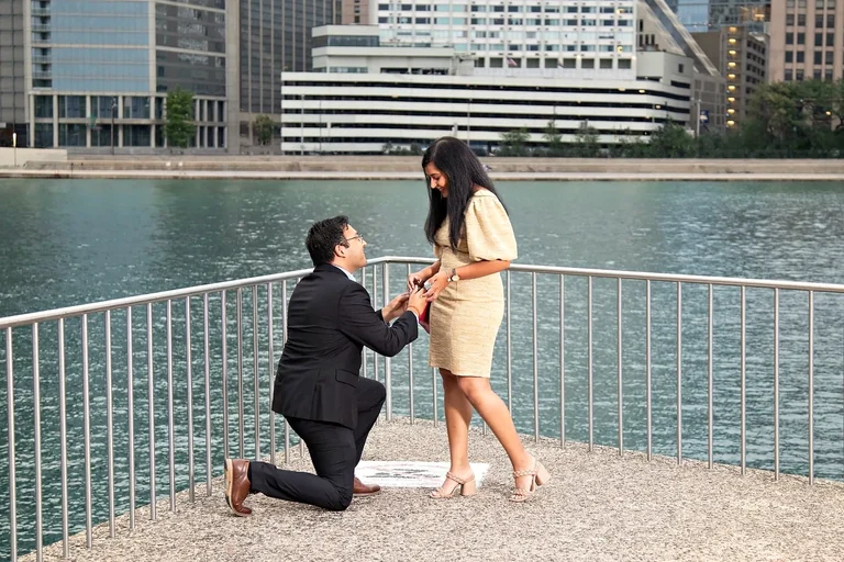 Surprise marriage proposal on one knee at the Chicago Riverwalk during a golden sunset, engagement photography by The Love Pics
