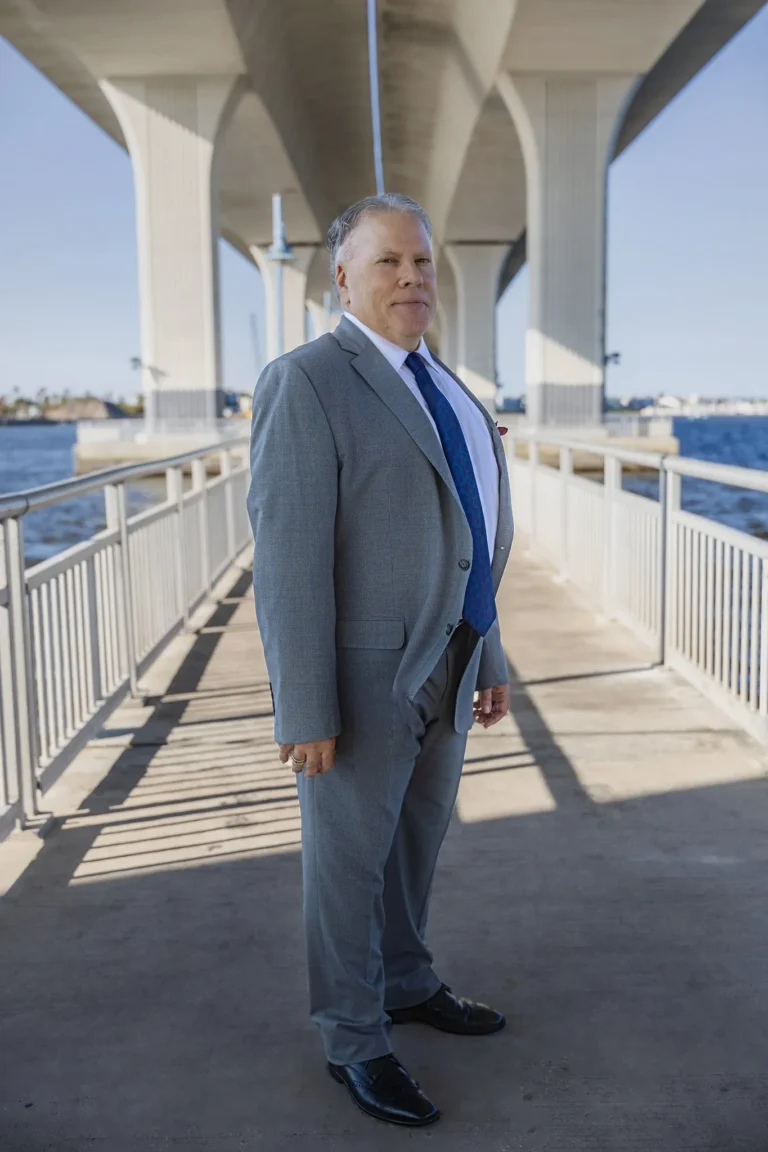 Attorney portrait outdoors near a bridge in Palm Beach