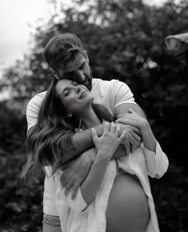 Black and white maternity portrait of a couple holding the bump