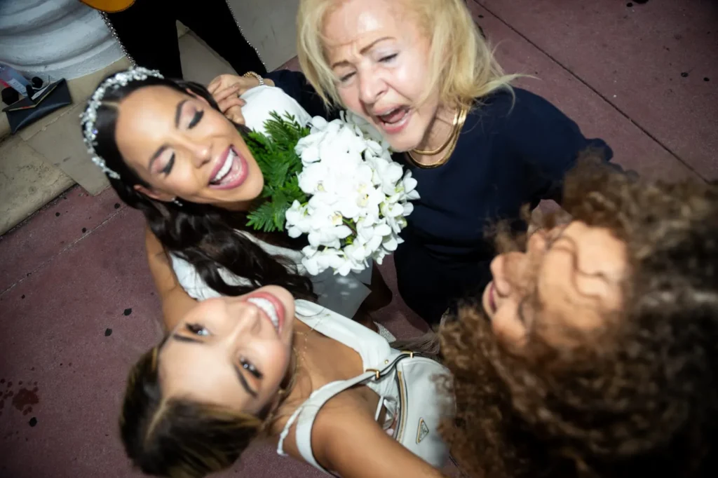 Joyful bride hugs her family in a group embrace after the ceremony