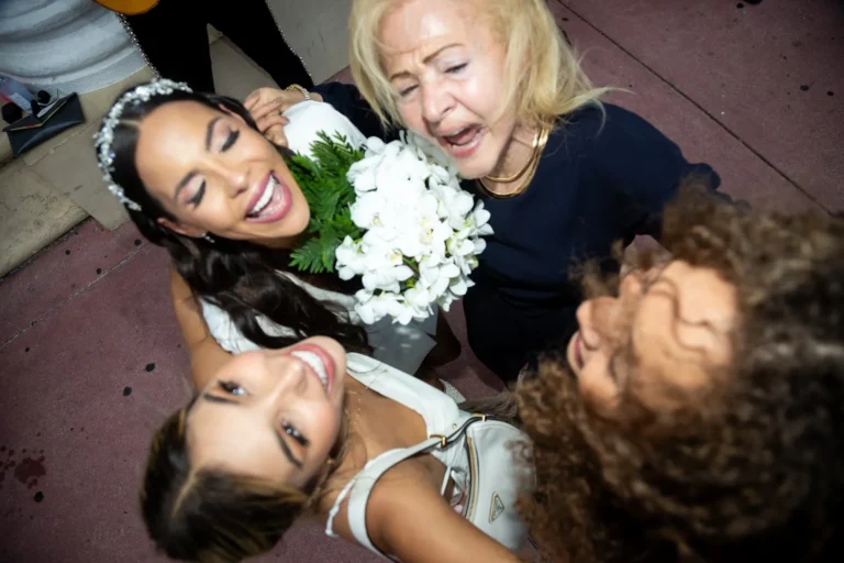 Joyful bride hugs her family in a group embrace after the ceremony
