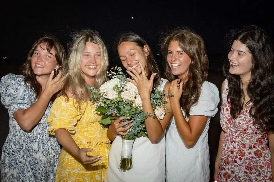 Bride-to-be celebrating her engagement with friends admiring the ring on a West Palm Beach beach