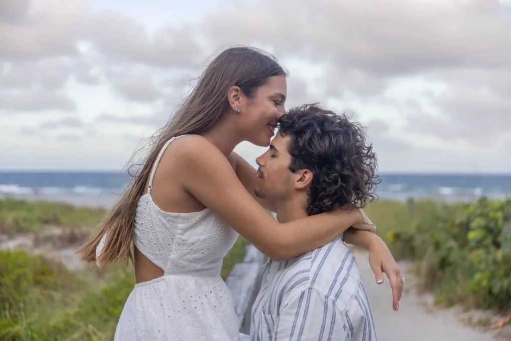 Pareja abrazándose junto al mar al atardecer