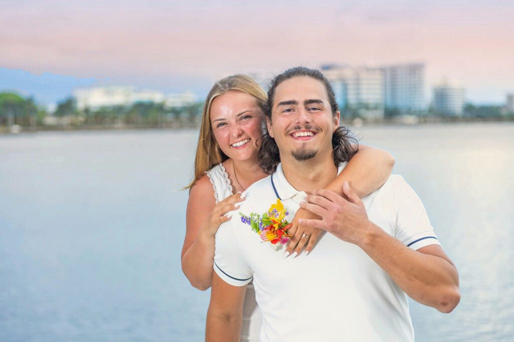 Newly engaged couple smiling by the water in Palm Beach after a surprise proposal at sunset