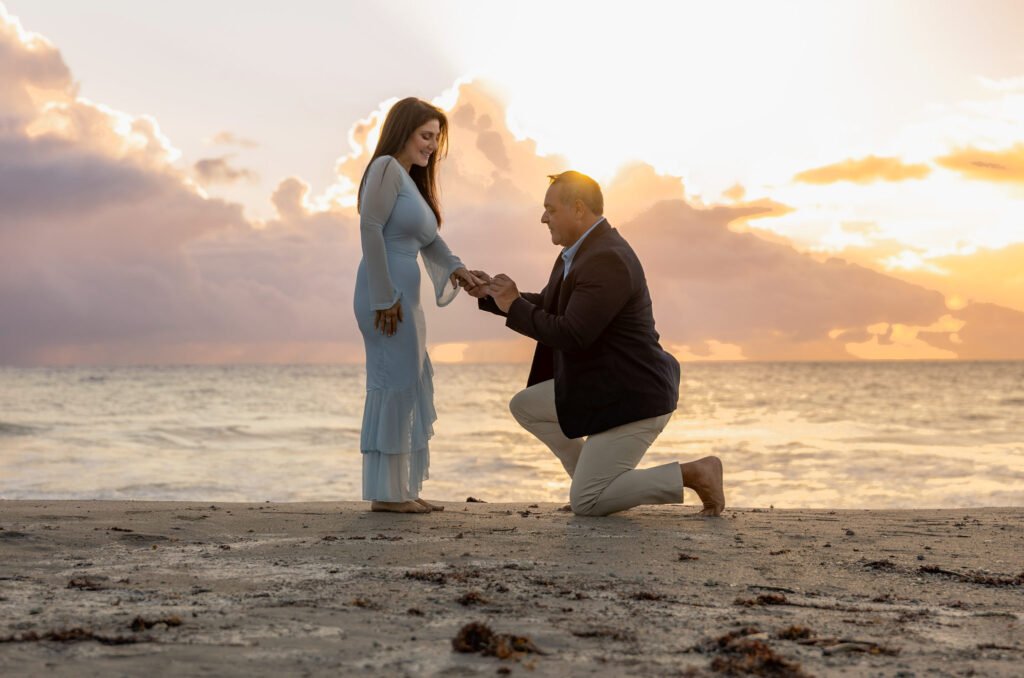Man kneeling with a ring on the beach at sunrise in Palm Beach